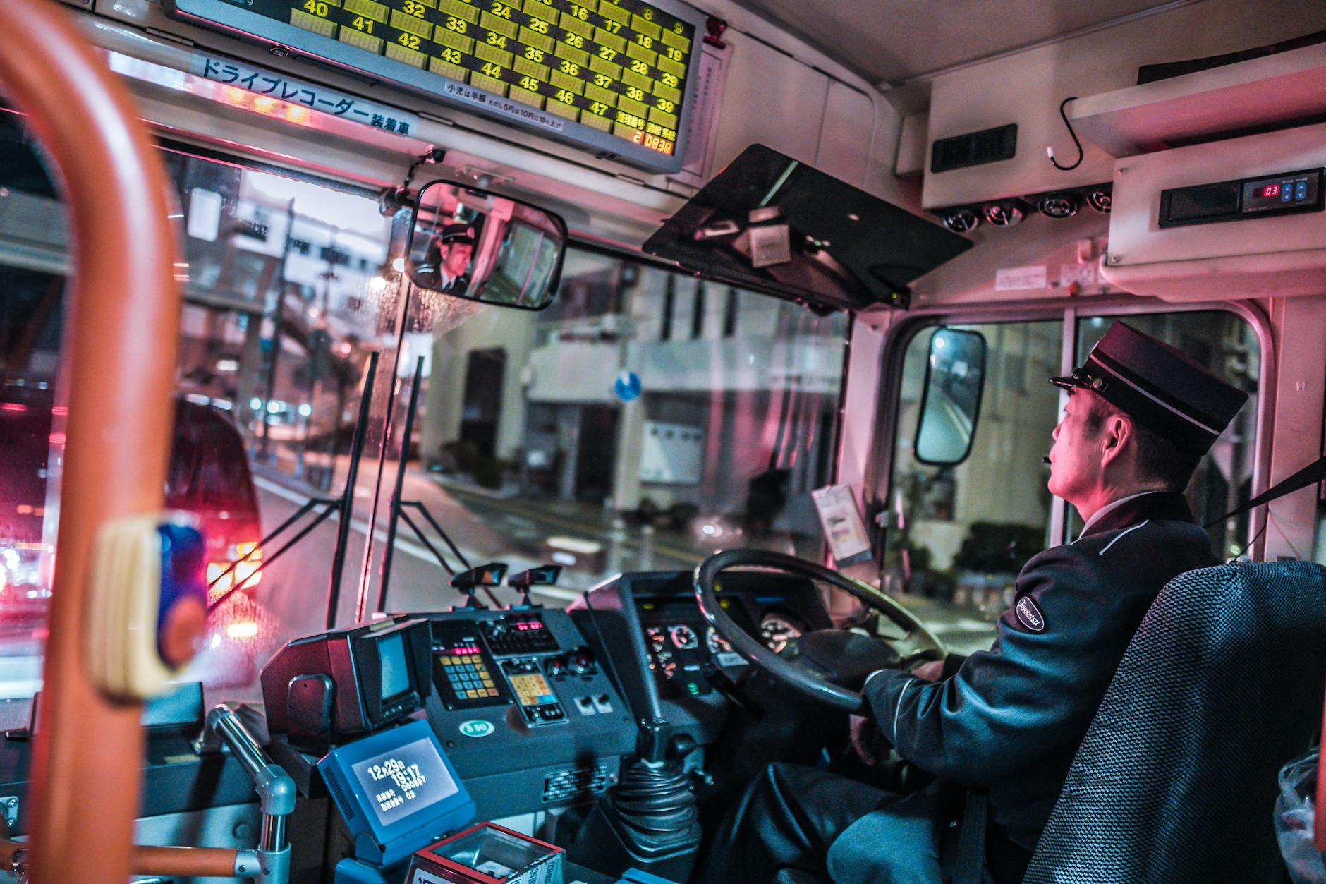 כמה מרוויח נהג אוטובוס - A city bus driver navigates the streets at night, showcasing public transportation in an urban setting.