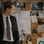 חוקר משטרה בחליפה מול לוח חקירה